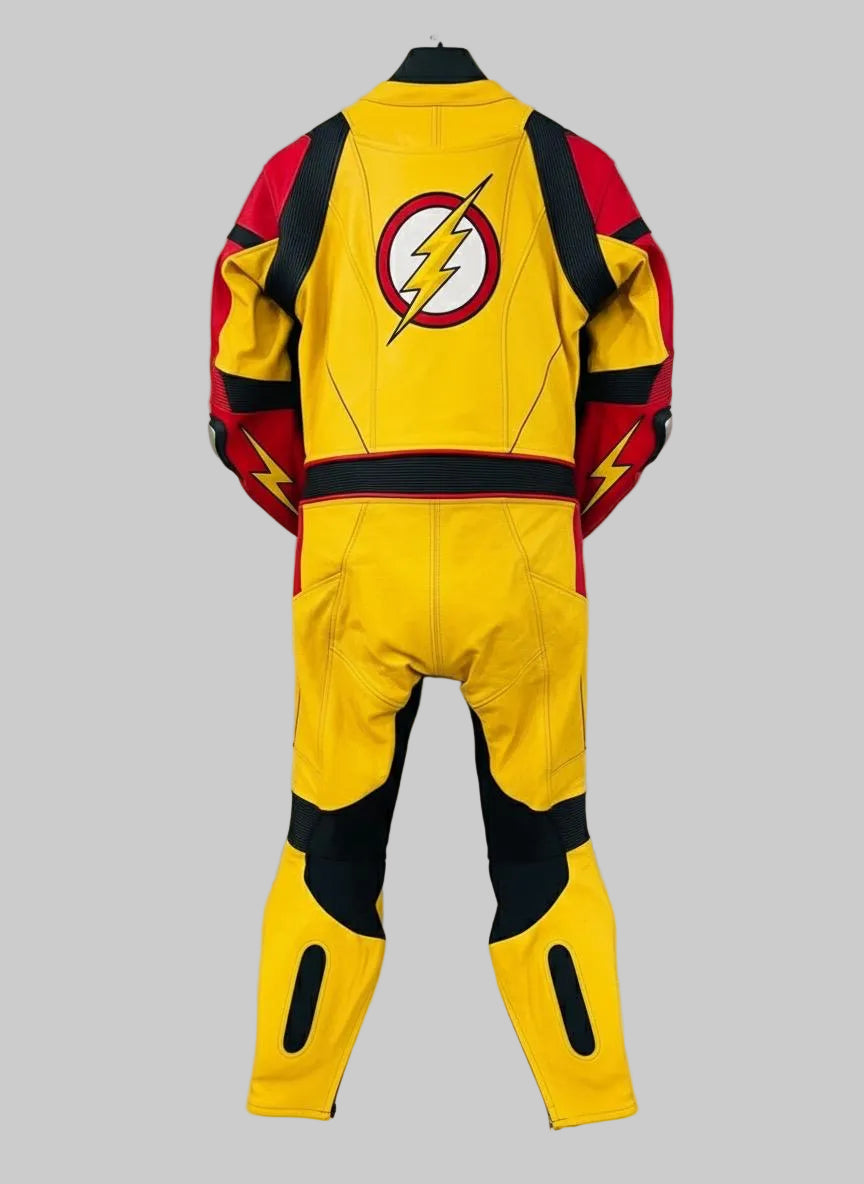 A yellow, red, and black superhero-style one-piece jumpsuit or racing suit hanging on a black hanger against a white wall. The back view shows a large circular lightning-bolt emblem on the upper back, red shoulder panels, black side sections, and yellow leg sections with black cutout details.